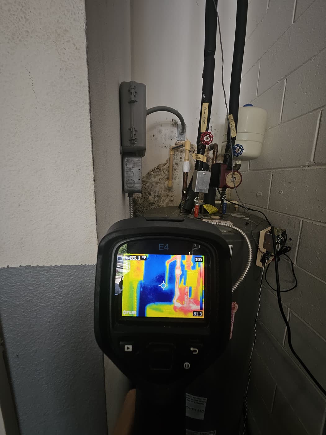 Technician using a thermal camera to find hidden moisture